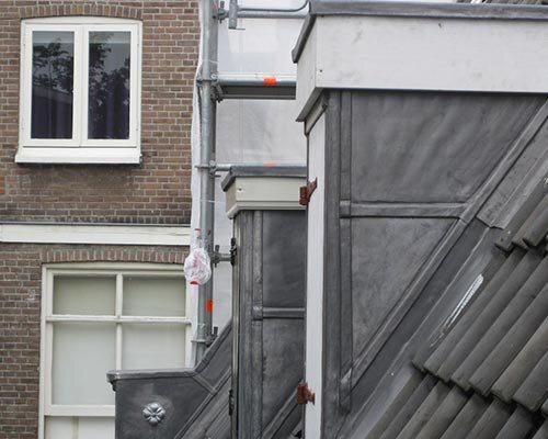 Zinken gevelbekleding op aanbouwen aan de achterzijde van Amsterdamse panden