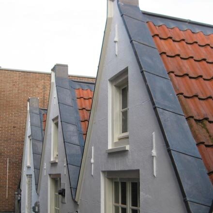 Rij puntgevels met nieuwe loodbekleding langs het pannendak